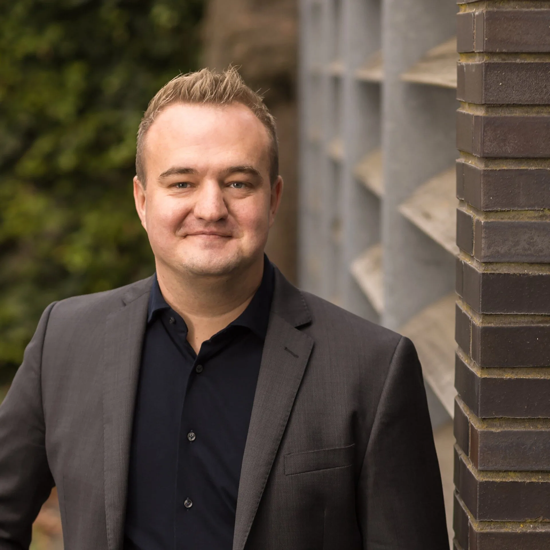 René Otto, founder of Deviant Legal, smiling in a business suit.