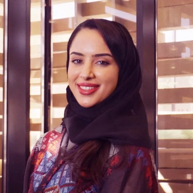 Danna Albanyan, smiling in front of a windowed backdrop.