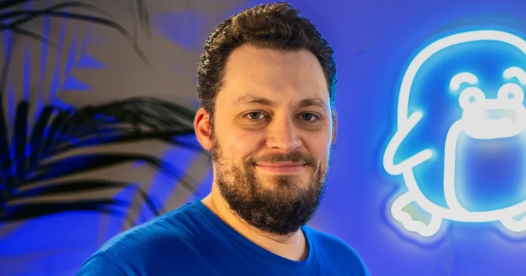 Koen Deetman, smiling in front of a glowing KeokeN Interactive logo.
